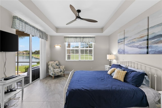 bedroom featuring a tray ceiling, ceiling fan, and access to exterior