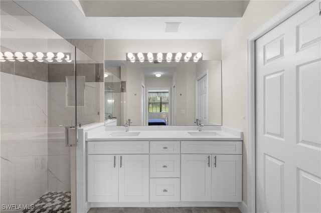 bathroom featuring a shower with door and vanity