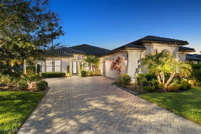 mediterranean / spanish-style house featuring a front yard and a garage