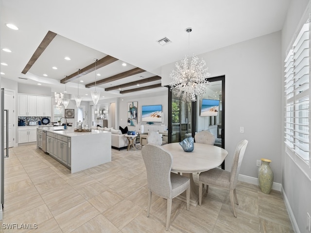 dining space with a healthy amount of sunlight, sink, and an inviting chandelier