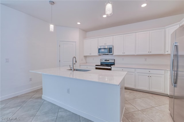 kitchen featuring an island with sink, white cabinets, appliances with stainless steel finishes, and decorative light fixtures