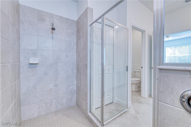 bathroom with walk in shower, toilet, and tile patterned floors