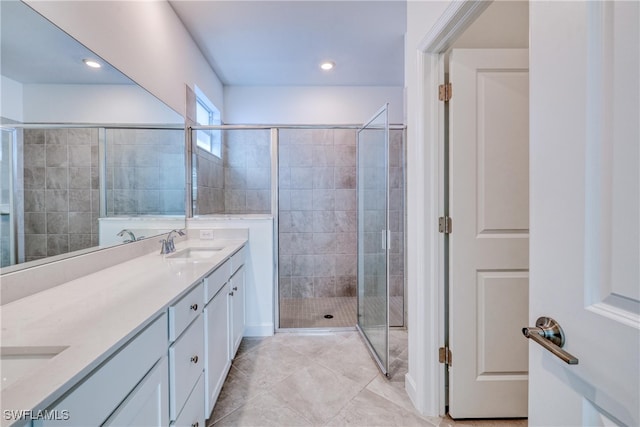 bathroom with walk in shower, vanity, and tile patterned floors