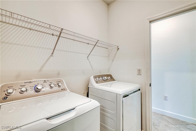 laundry area with light tile patterned flooring and washer and clothes dryer