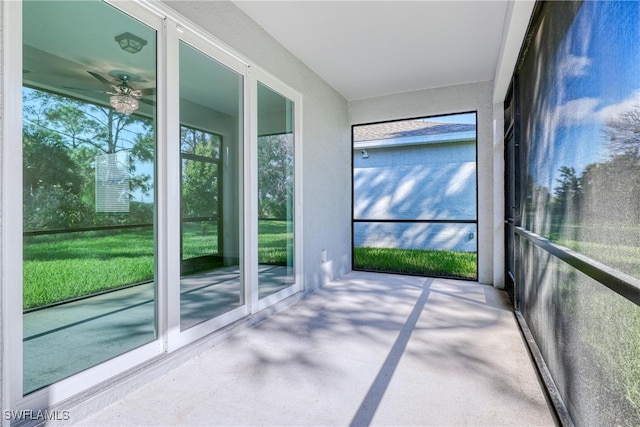 unfurnished sunroom featuring ceiling fan