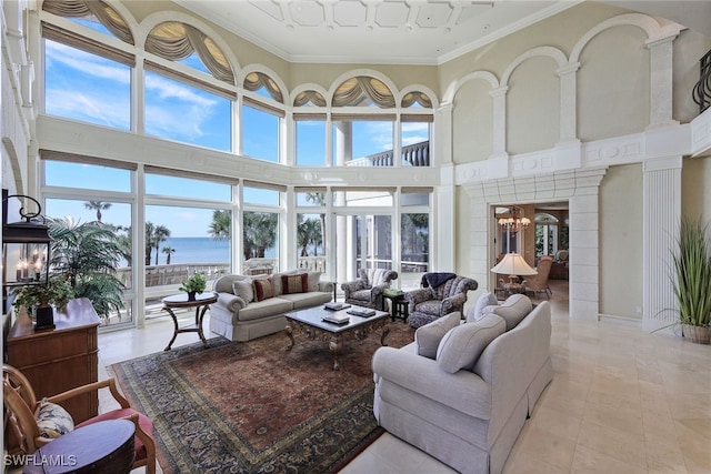 sunroom with a chandelier, plenty of natural light, and a water view