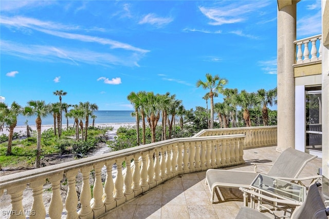 balcony featuring a water view and a view of the beach