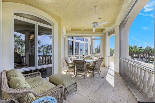 sunroom / solarium featuring a ceiling fan