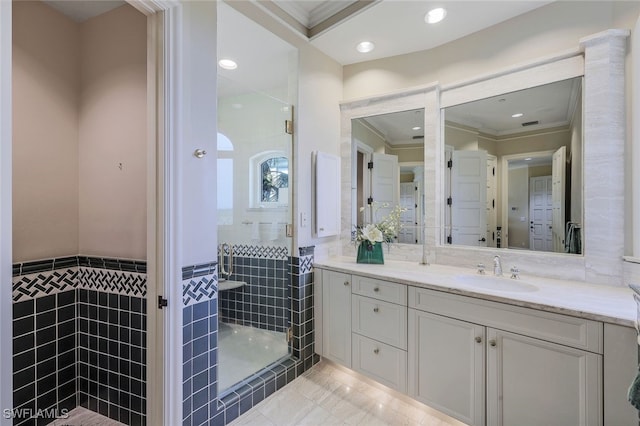 bathroom with tile walls, crown molding, a shower stall, and vanity