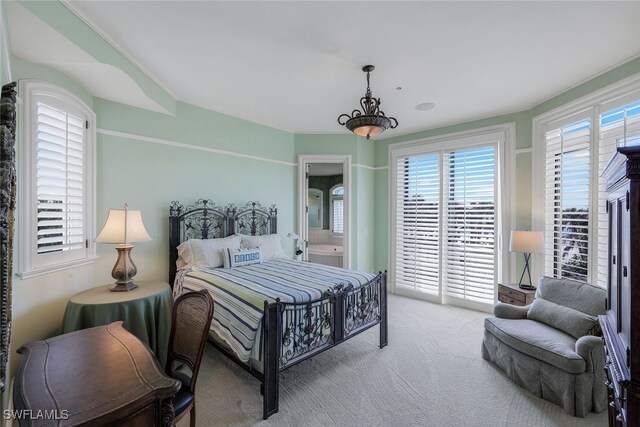 carpeted bedroom featuring access to exterior and ensuite bath