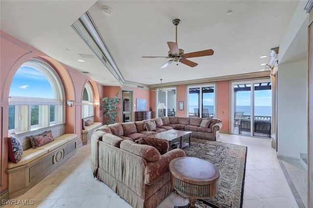 living area featuring ornamental molding, a tray ceiling, ceiling fan, and recessed lighting