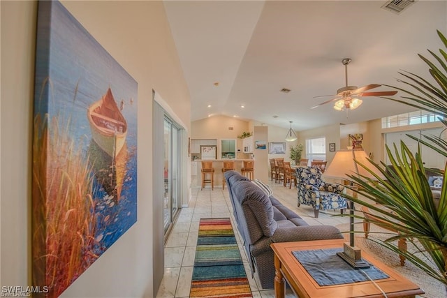 tiled living room with ceiling fan and vaulted ceiling