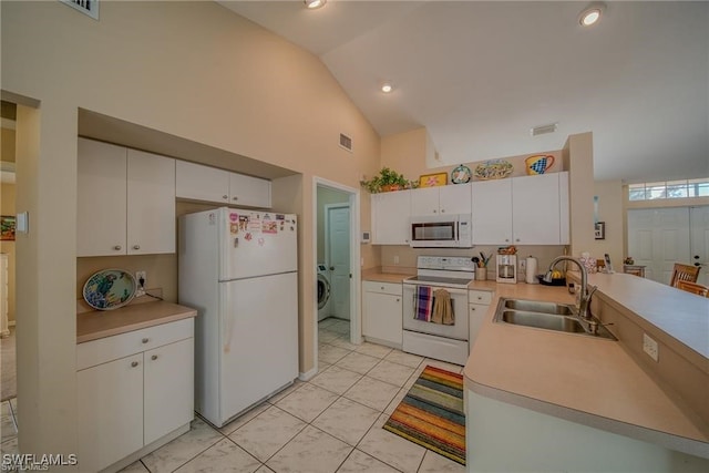 kitchen with white cabinets, sink, white appliances, high vaulted ceiling, and washer / dryer