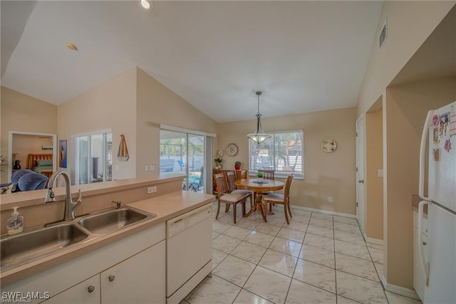 kitchen featuring vaulted ceiling, white cabinets, white appliances, decorative light fixtures, and sink