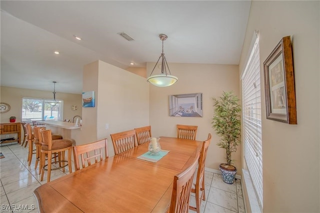 dining area featuring light tile patterned floors and vaulted ceiling