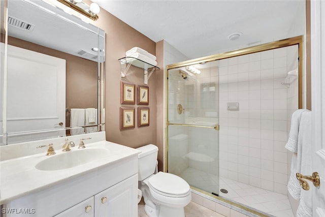 bathroom featuring vanity, a shower with shower door, toilet, and tile patterned floors