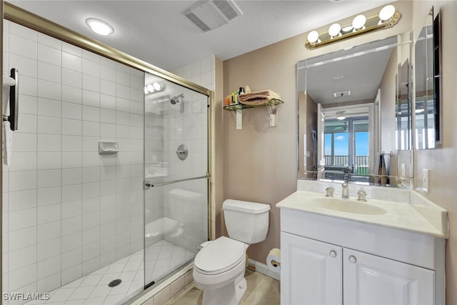 bathroom featuring vanity, toilet, and an enclosed shower