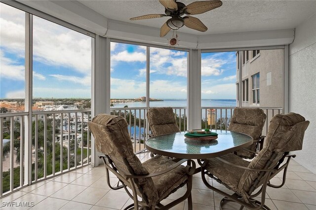 14250 Royal Harbour Ct Unit 817, Fort Myers, FL 33908 - sunroom featuring a water view, tile patterned flooring, a textured ceiling, and a textured wall