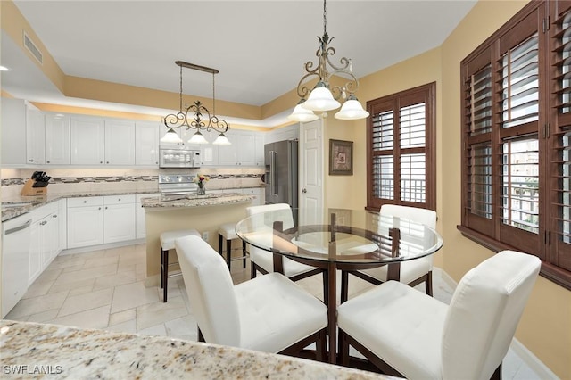 14250 Royal Harbour Ct Unit 817, Fort Myers, FL 33908 - dining room featuring a chandelier and baseboards