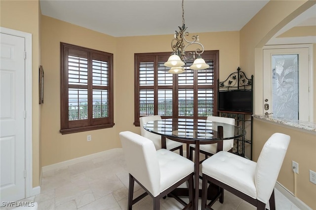 14250 Royal Harbour Ct Unit 817, Fort Myers, FL 33908 - dining room with baseboards, arched walkways, and a chandelier