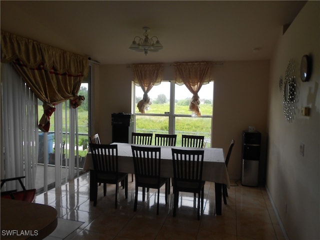 tiled dining room featuring an inviting chandelier