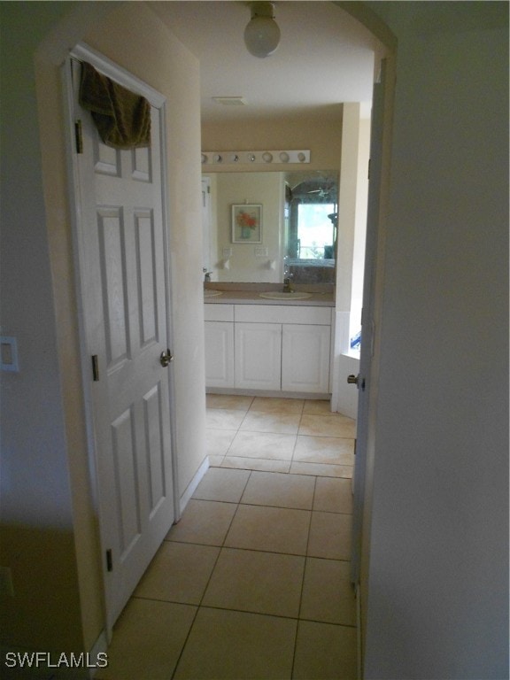 corridor featuring sink and light tile patterned floors