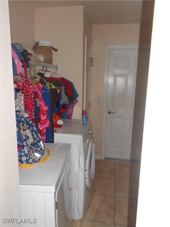 washroom featuring washer and clothes dryer and light tile patterned flooring