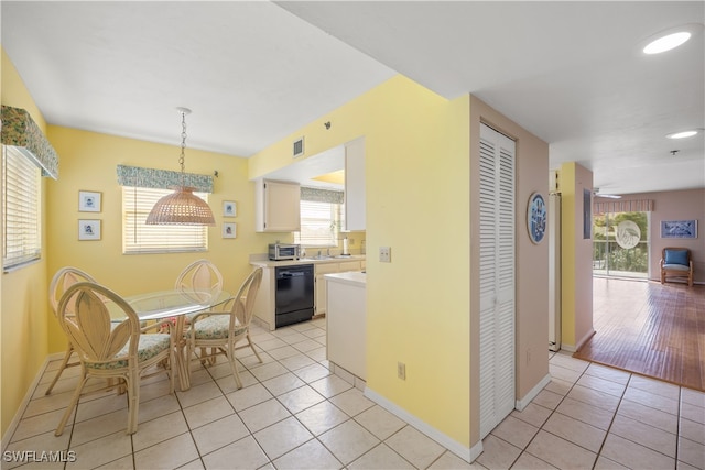 kitchen with light wood-type flooring, hanging light fixtures, white cabinetry, and dishwasher