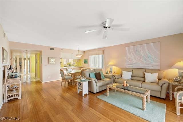 living room with ceiling fan and light wood-type flooring