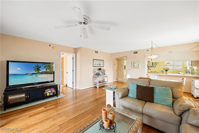 living room with ceiling fan and light hardwood / wood-style floors