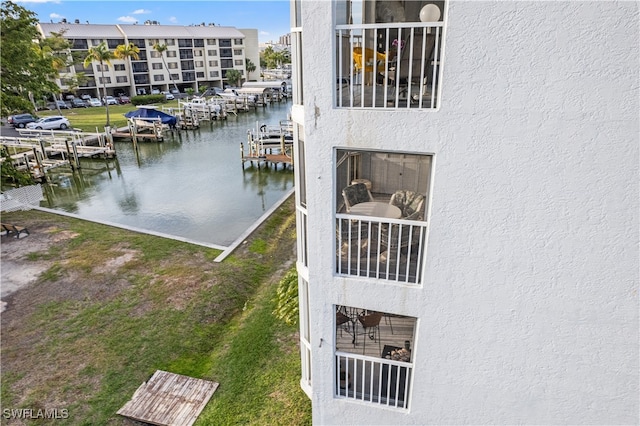 view of dock with a yard and a water view