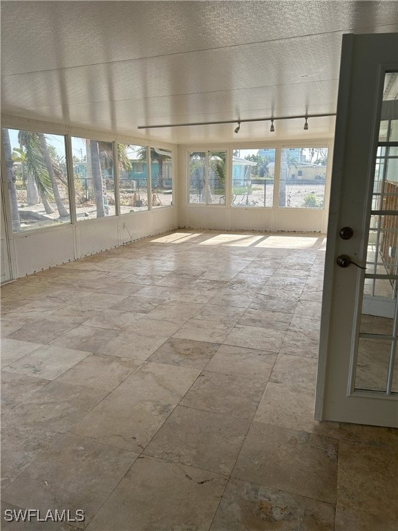 unfurnished sunroom with track lighting