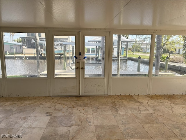 unfurnished sunroom featuring a water view, french doors, and plenty of natural light