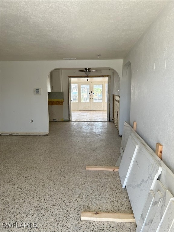 interior space featuring french doors, a textured ceiling, and ceiling fan