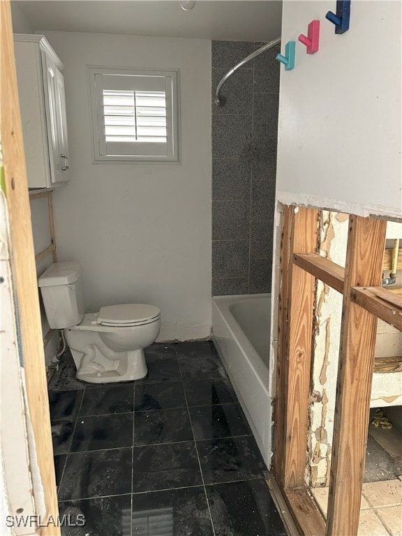 bathroom with toilet, tile patterned floors, and tiled shower / bath combo