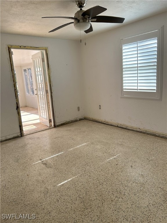 spare room with a textured ceiling and ceiling fan