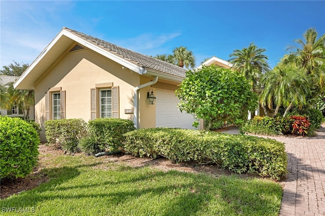 view of side of home with a garage and stucco siding