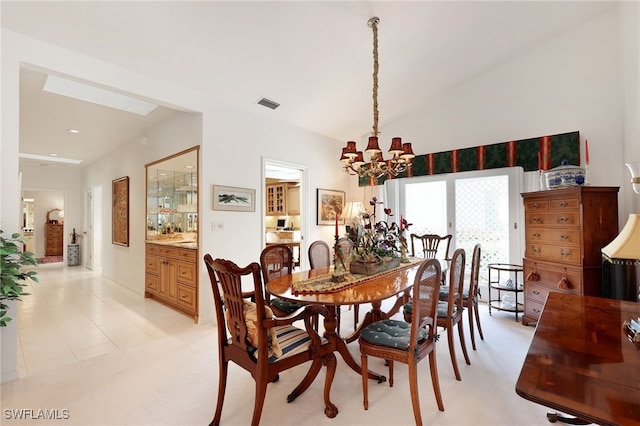 dining area with light carpet, a notable chandelier, vaulted ceiling, and visible vents