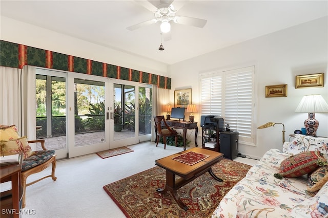 carpeted living area with french doors and ceiling fan