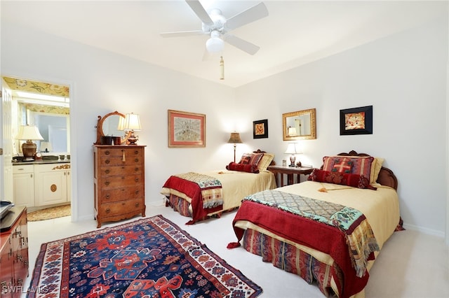 bedroom featuring ceiling fan, ensuite bath, and light carpet