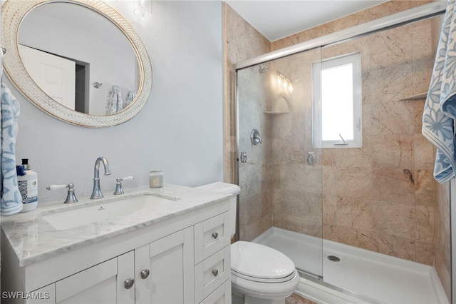 bathroom featuring vanity, toilet, and an enclosed shower