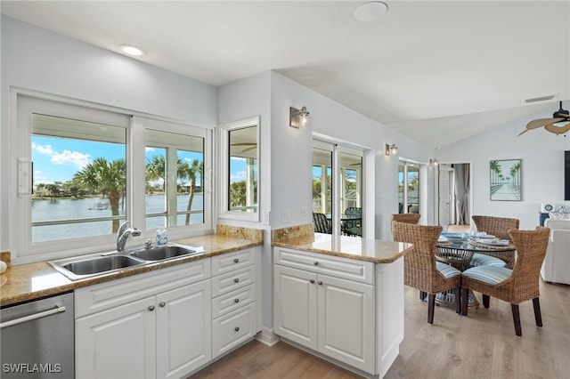 3311 Twin Lakes Ln, Sanibel, FL 33957 - kitchen with stainless steel dishwasher, open floor plan, lofted ceiling, white cabinets, and light wood-style flooring