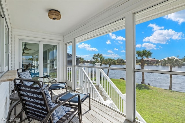 deck with a water view and a yard