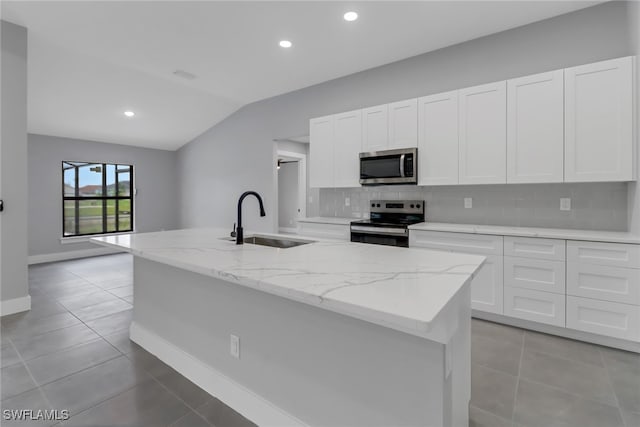 kitchen featuring a center island with sink, appliances with stainless steel finishes, backsplash, and white cabinetry