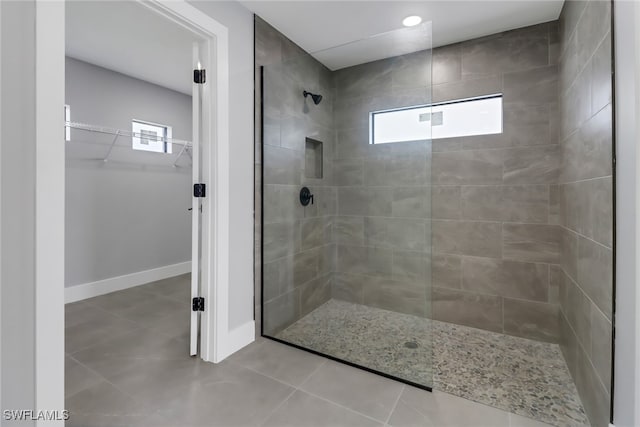 bathroom featuring a tile shower and tile patterned flooring