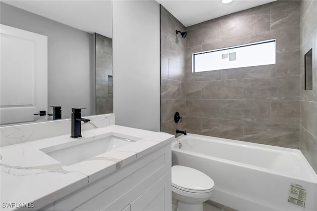 full bathroom featuring vanity, tiled shower / bath combo, and toilet