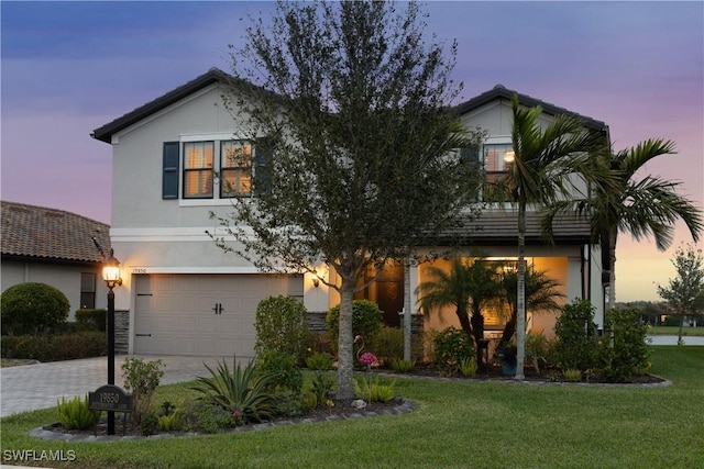 view of front facade featuring a garage and a yard