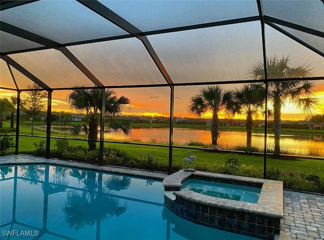 pool at dusk with a water view, a lanai, and an in ground hot tub