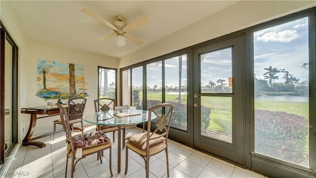 sunroom featuring a water view and ceiling fan