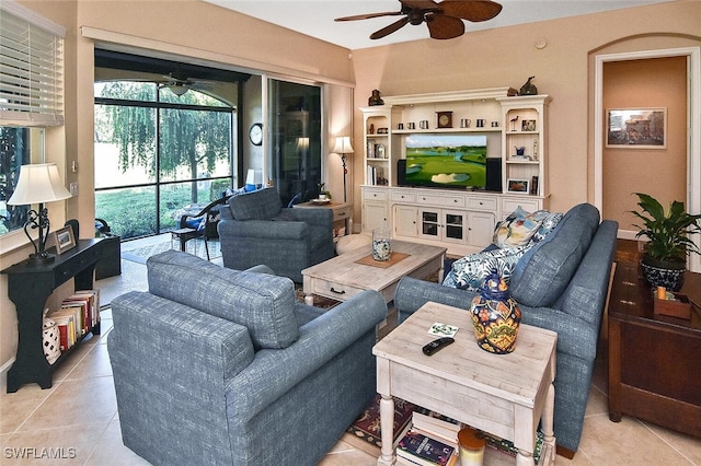 living area with light tile patterned floors, a sunroom, and ceiling fan